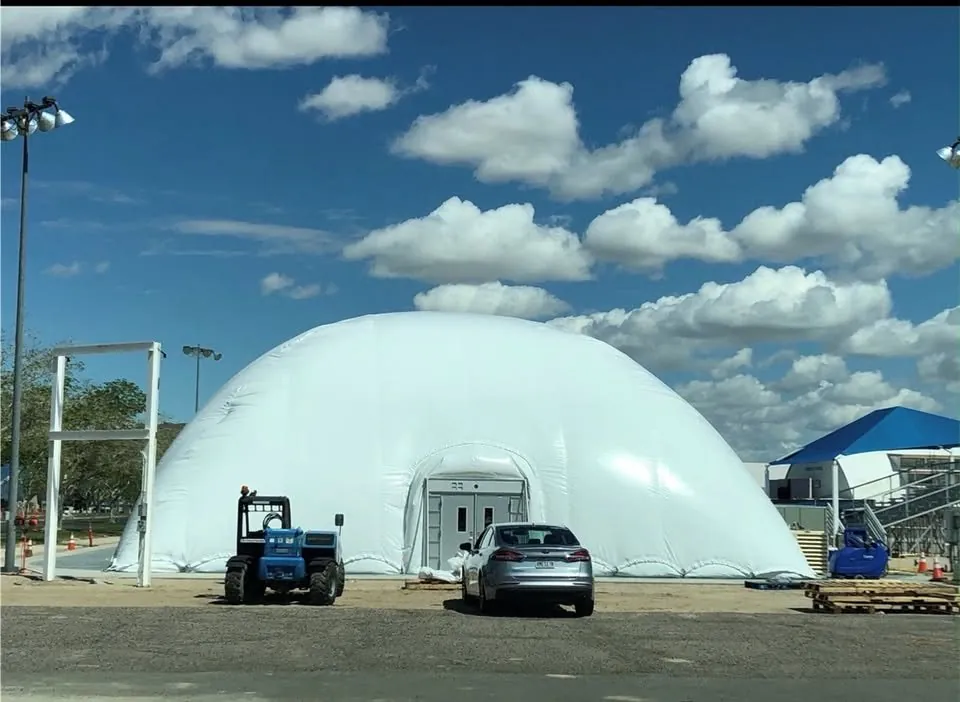 End view of the air dome with a forklift and car parked alongside for scale